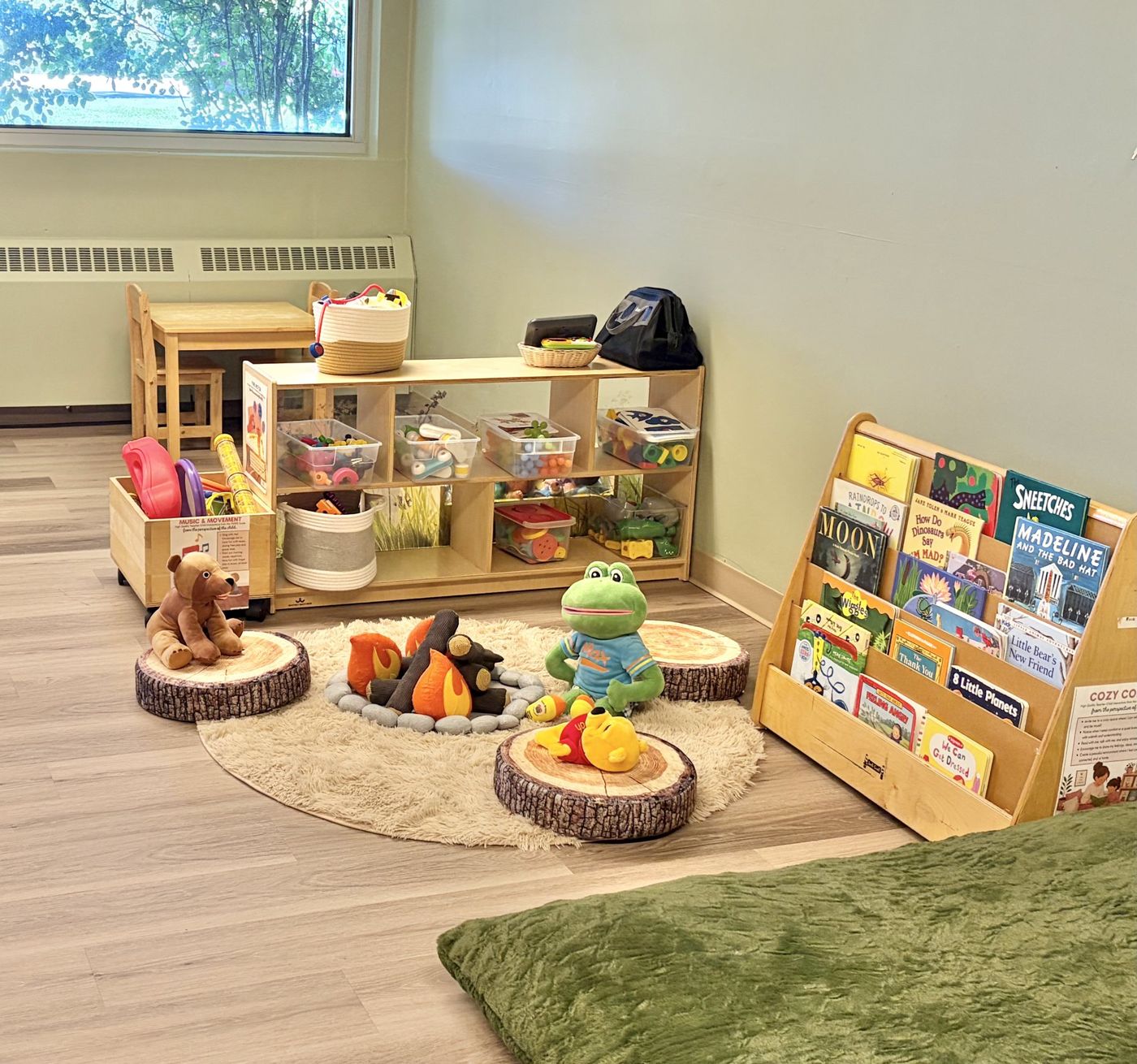 A cozy reading corner with books, a rug and play pieces